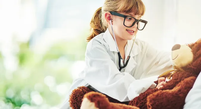 Kind hört als engagierte Ärztin ihren Teddybären mit einem Stethoskop ab
