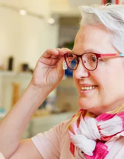 Eine Frau probiert Brillengestelle und scheint fündig geworden zu sein