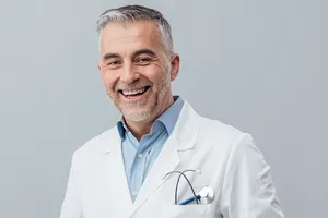Portraitaufnahme eines freundlichen Arztes mit Stethoskop in der Brusttasche