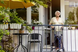 Seniorin steht in der Tür zu Ihrer Terrasse