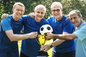 Vier Teilnehmer der siegreichen Herrenmannschaft posieren mit Pokal und Ball