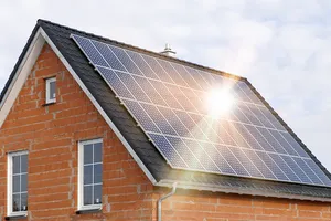 Eine nagelneue vollflächige Photovoltaikanlage glänzt auf dem Dach in der Abendsonne