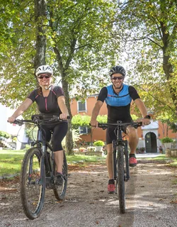 Ein junges Paar startet bei bestem Wetter und in voller Montur zur Fahrradtour