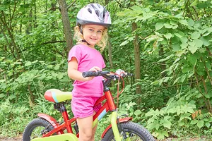Kleines Mädchen posiert an diesem sonnigen Sommertag auf ihrem roten Fahrrad