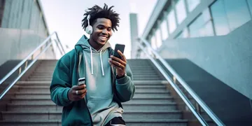 Junger Mann mit Handy geht eine große Treppe hinunter.